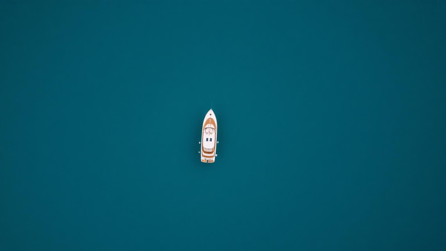 Aerial view of a single yacht on calm open water